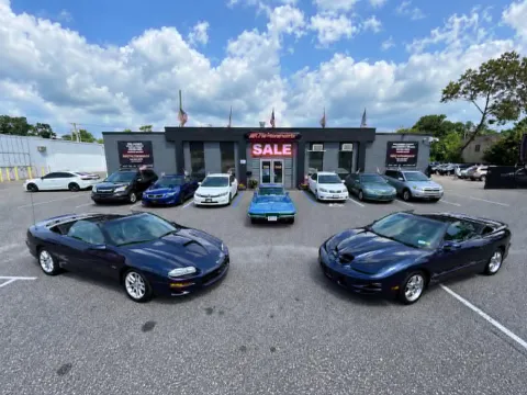 Specialty cars lined up on the front lot at AR Motorsports in Bay Shore, NY