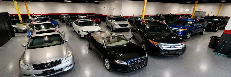 Dozens of used cars inside the climate-controlled indoor showroom at AR Motorsports in Bay Shore, NY